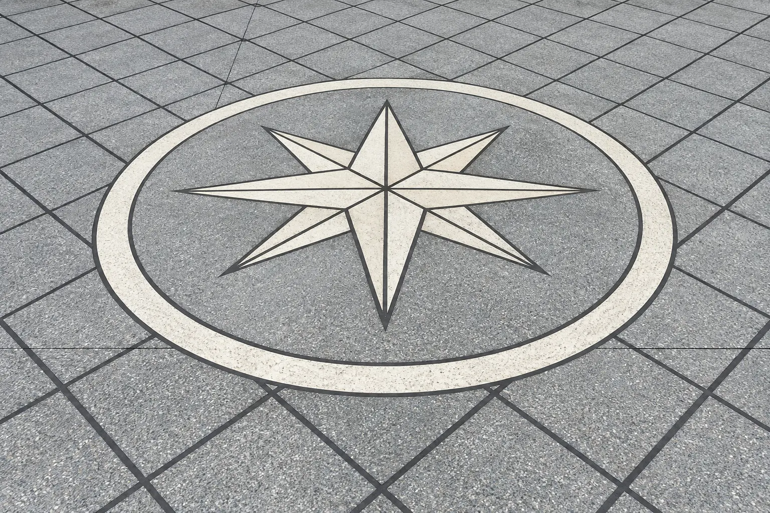 Custom stained and scored concrete driveway with an eight-point compass medallion
